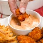 dipping a nugget in pink sauce