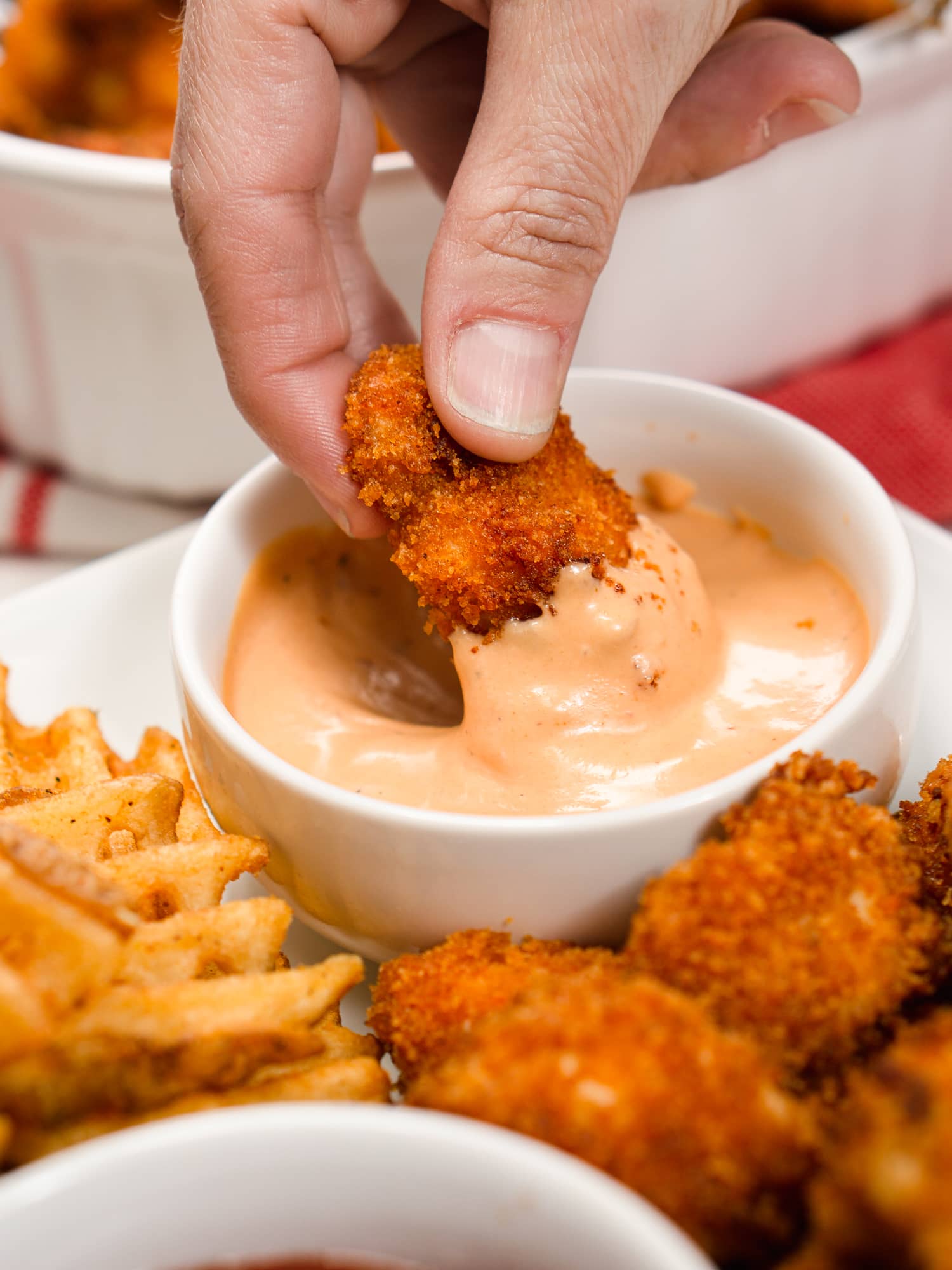 dipping a nugget in pink sauce