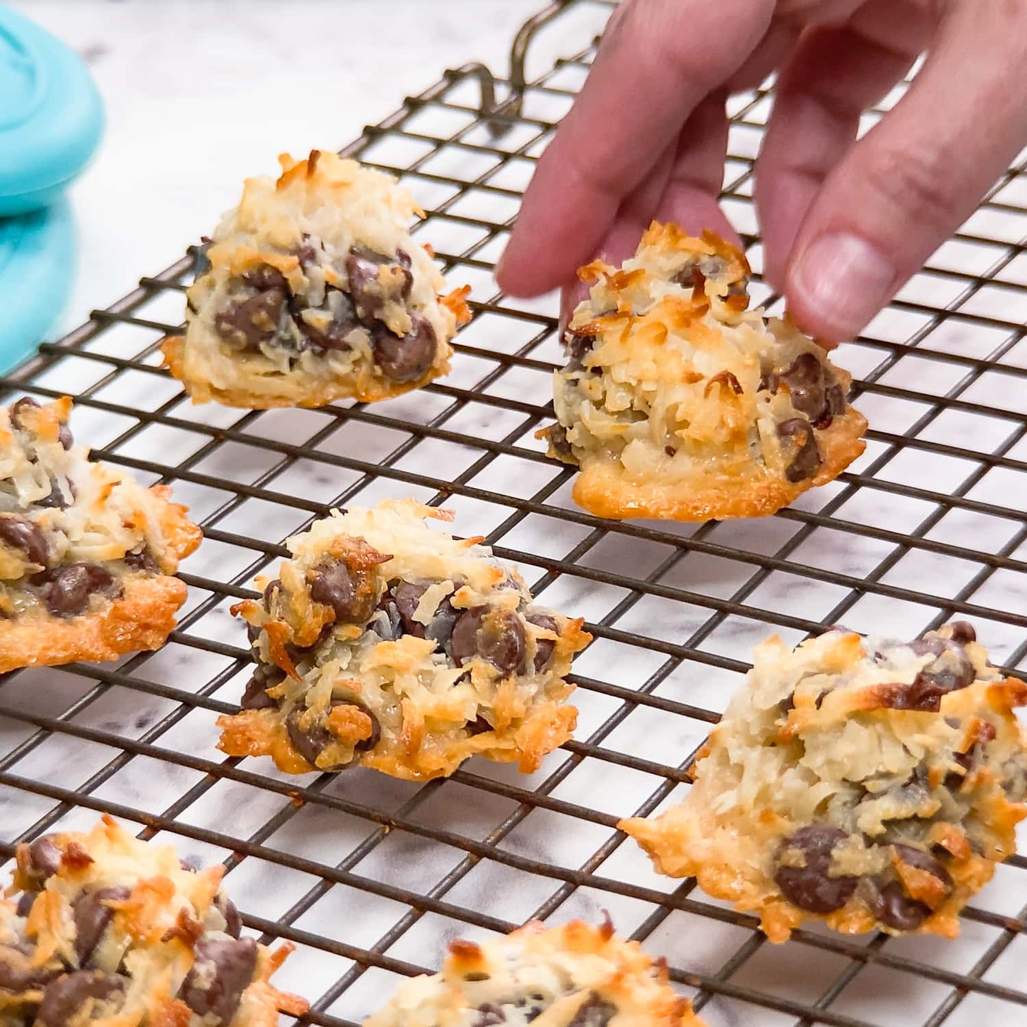 placing chocolate chip coconut macaroons on a cooling rack