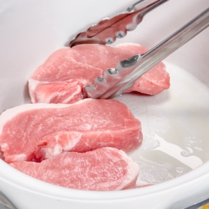 placing pork chops in the slow cooker