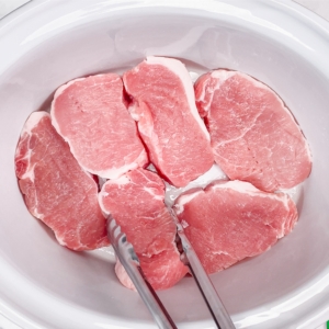 placing pork chops in the slow cooker