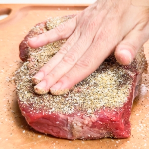 rubbing seasoning mix into chuck roast