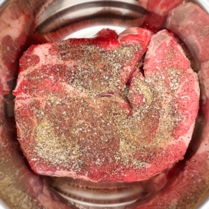 a seasoned chuck roast sitting in the instant pot for making carne mechada