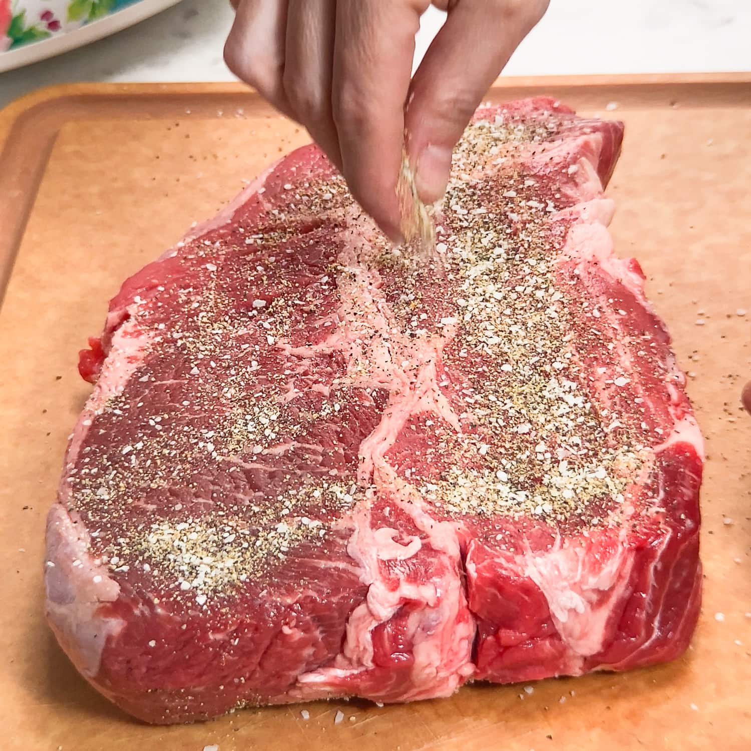 seasoning a chuck roast with salt pepper and garlic powder