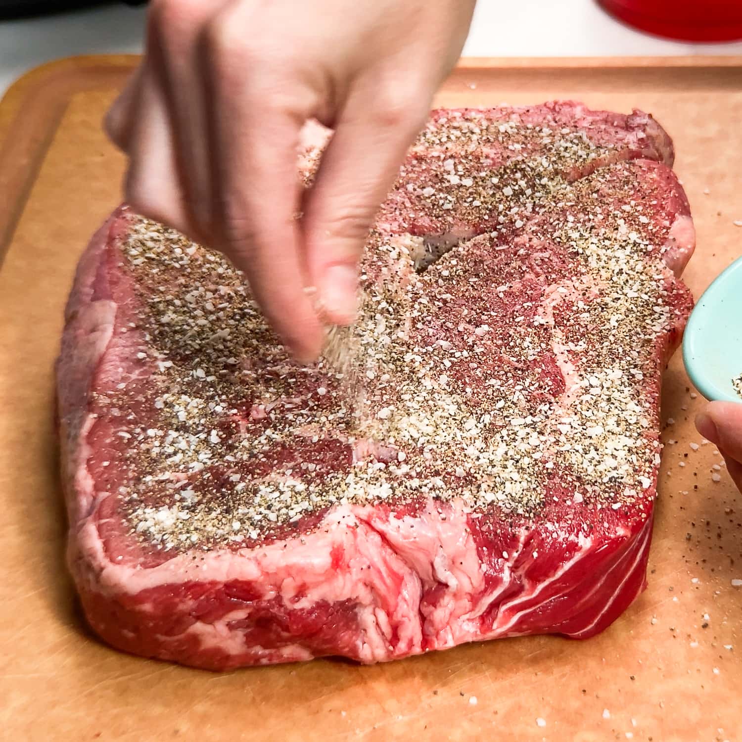 seasoning chuck roast with salt, pepper, and garlic powder