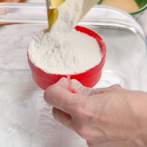 adding cassava flour to a measuring cup