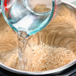 adding water over brown rice in the pressure cooker