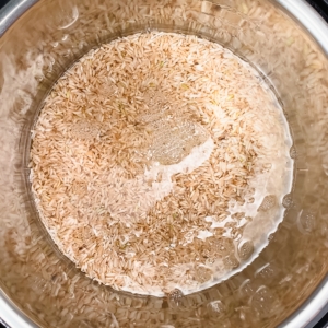 brown rice and water in the pressure cooker before cooking