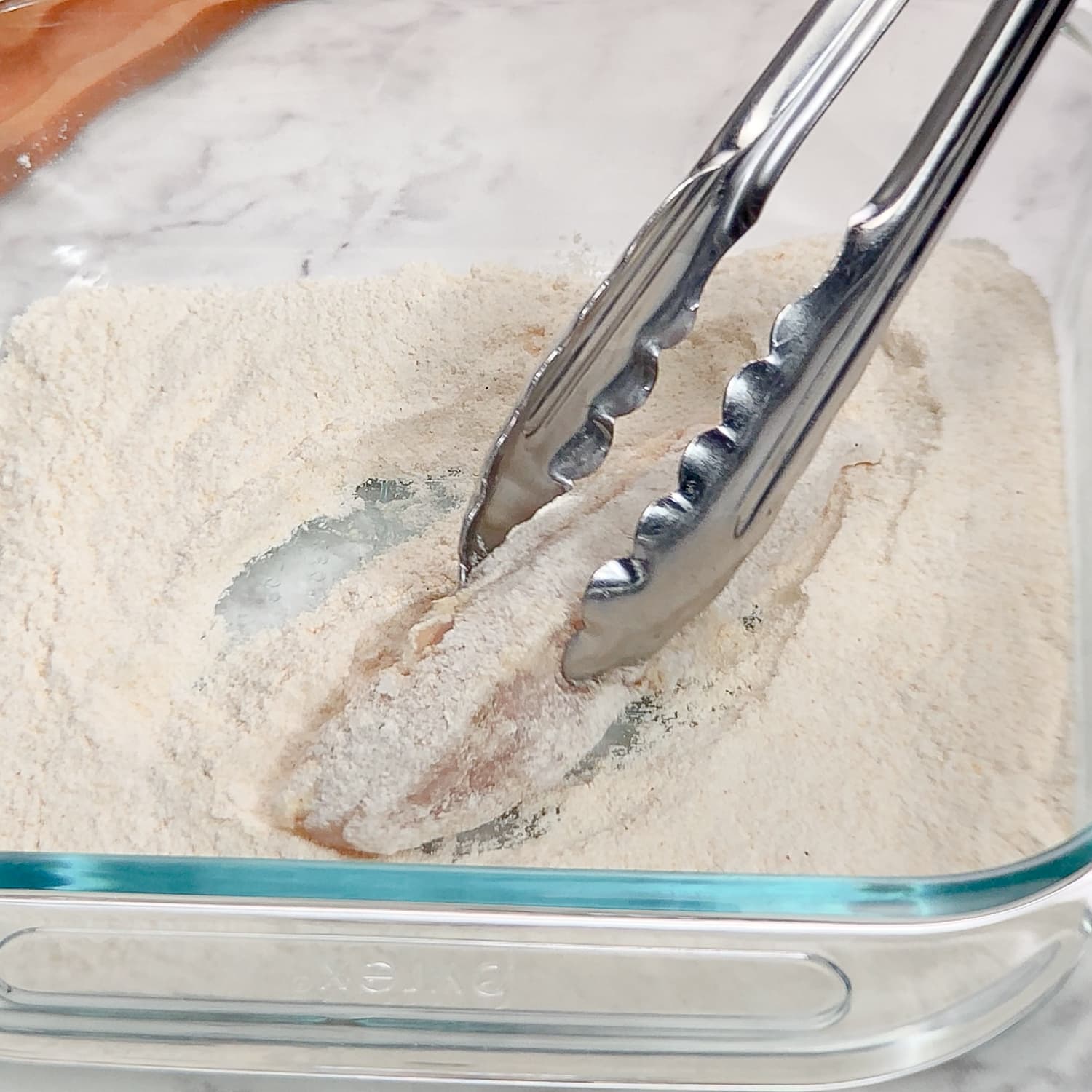 coating a chicken tender in gluten-free breading