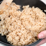 transferring brown rice to a serving dish after cooking