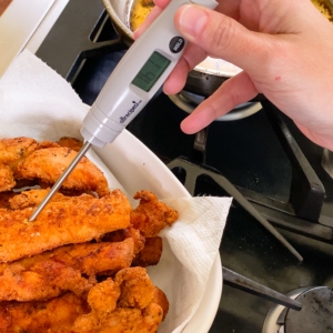 using a meat thermometer to check the internal temperature of gluten free chicken tenders