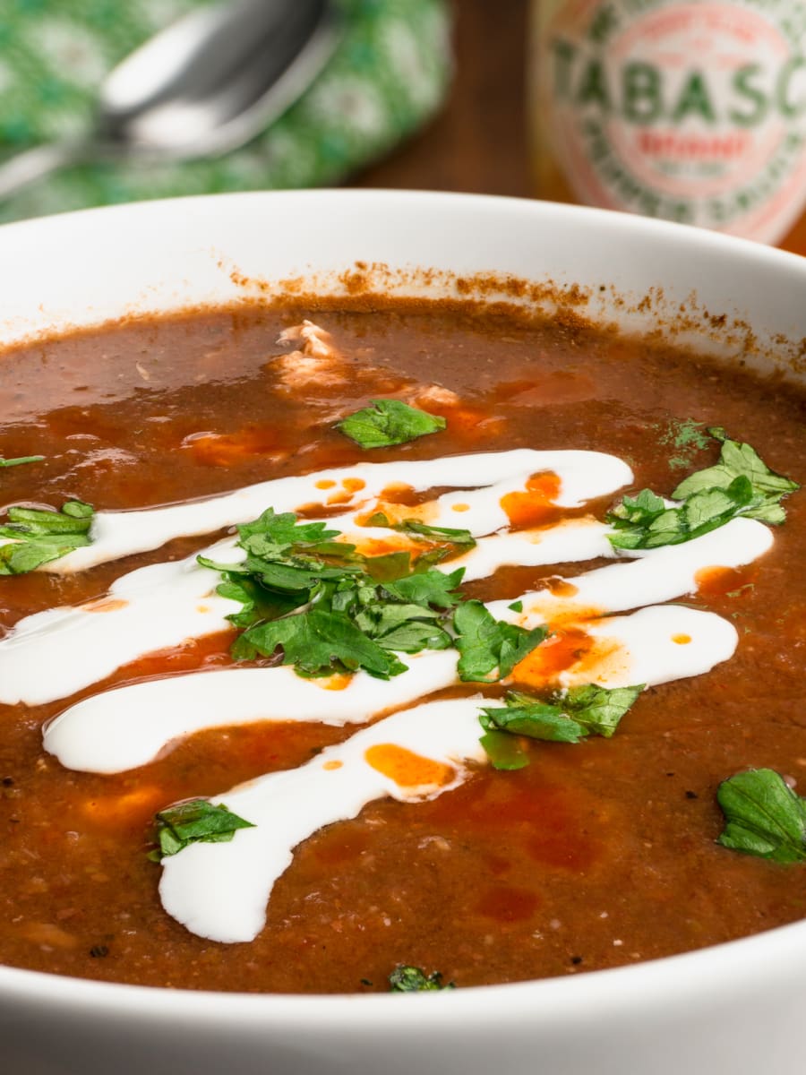 red bean soup in a bowl drizzled with mantequilla and garnished with cilantro