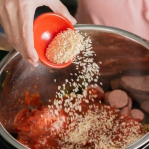 adding dried minced onion over layers of pasta, sausage, and marinara sauce in the instant pot