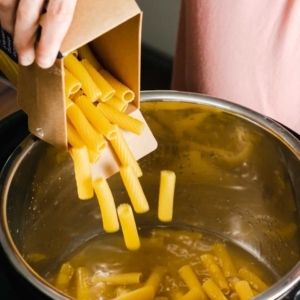 pouring rigatoni pasta into the instant pot