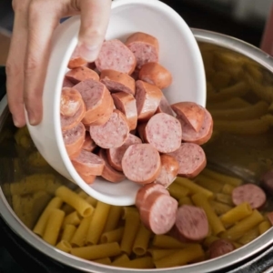 layering sausage over a layer of rigatoni pasta in the instant pot