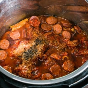 layers of pasta, marinara sauce, sausage, and spices in the instant pot after cooking