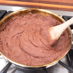 refried beans in a frying pan on the stovetop