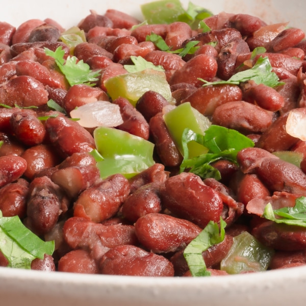 side view of a bowl of red bean stew with cilantro for garnish